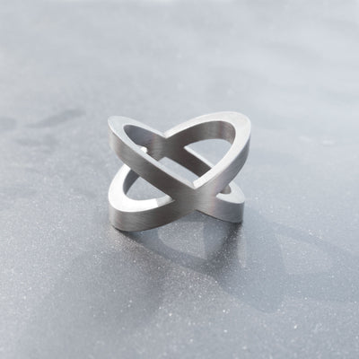 This is the Xenos ring. Shaped after a cross, the massive ring is yet refined, with simple, sharp lines. Despite its big and bold presence, the Xenos ring in titanium is very light and biocompatible.