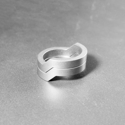 This is the Duality ring. Two parts of a same ring perfectly line up next to each other. They can be worn separately or even spread apart depending on your mood. The lines are simple yet defined, with a very geometric appearance. Being crafted from titanium it is very light, comfortable to wear and it is fully biocompatible.