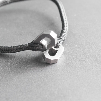 Aegis est un bracelet en parfaite adéquation, conçu pour rester avec vous à vie. Minimaliste et intemporel, il est fabriqué à la main à partir de titane grade 5 et d'une corde quasi indestructible. Les 2 parties du bracelet s'imbriquent avec précision et d'une façon unique et originale, s'inspirant du design traditionnel des menottes.