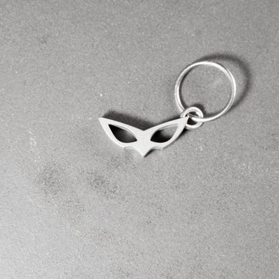 Joker's mask as an earring, perfectly recreated with faithful proportions. A seemingly simple 2D rendition of the mask and a minimalist, timeless piece to wear. Entirely handcrafted from grade 5 titanium.