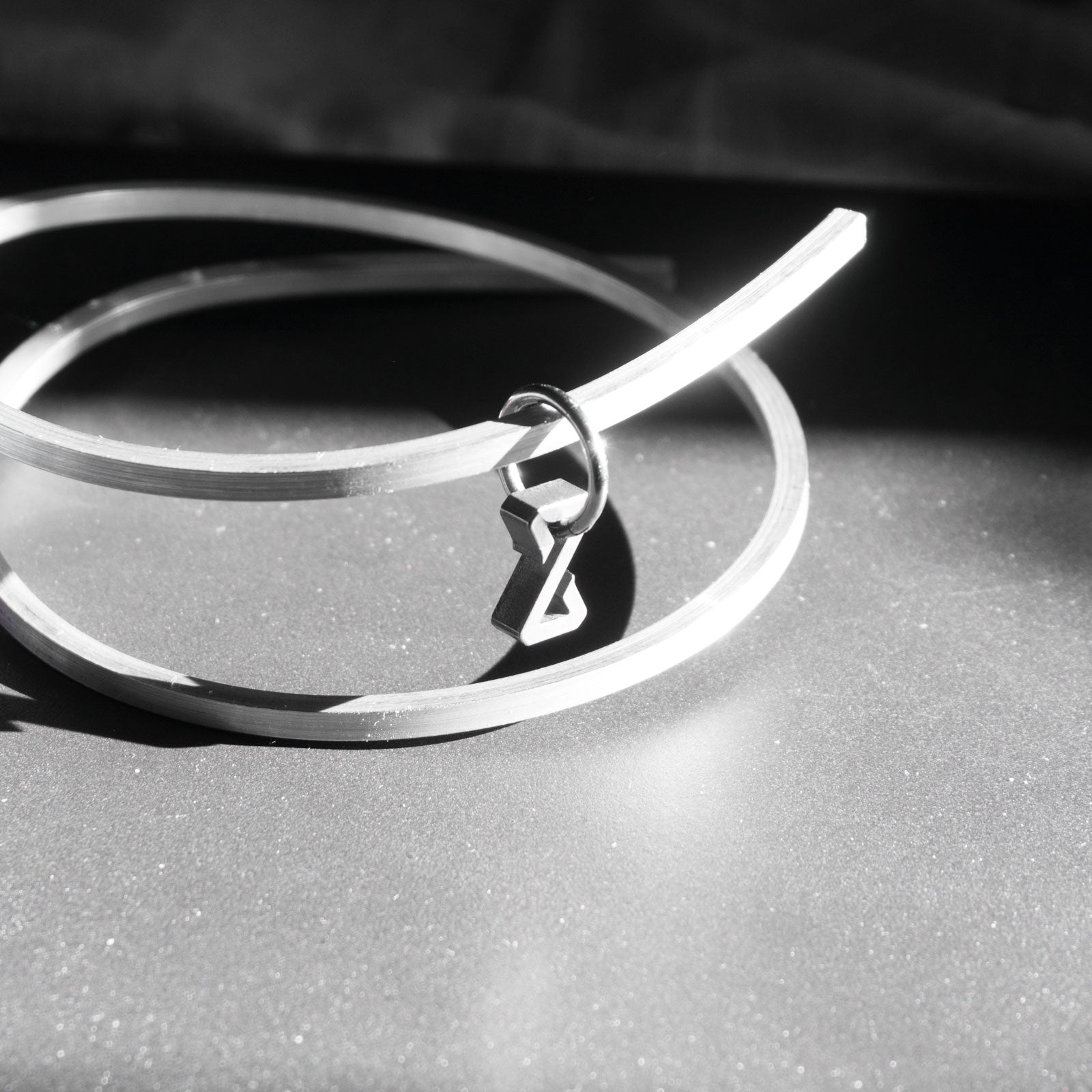 The Zenos earring is a minimalist, timeless shape, handmade from grade 5 titanium, meaning that it is super light to wear and is biocompatible. It is shaped after a broken hourglass, symbolizing time at a standstill. It is made to represent the impervious aspect of the earring, crafted to last forever.